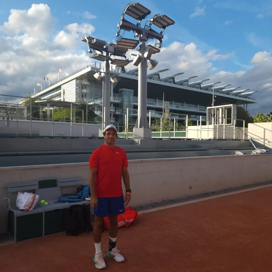 A man standing on top of a tennis court holding a racquet.